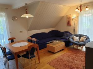 - un salon avec un canapé bleu et une table dans l'établissement Apartman Irvin, à Kranjska Gora