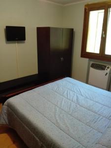 a bedroom with a bed with a dresser and a television at Il posto del ciliegio selvatico in Cavaliere