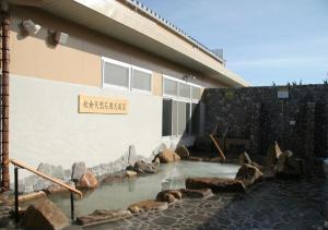 une piscine d'eau en face d'un bâtiment dans l'établissement Hidamarinoyu mix dormitory / Vacation STAY 40392, à Takayama