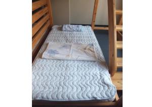 two bunk beds with white blankets on them at Hidamarinoyu mix dormitory / Vacation STAY 40392 in Takayama