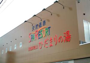 un panneau sur le côté d'un bâtiment dans l'établissement Hidamarinoyu mix dormitory / Vacation STAY 40392, à Takayama