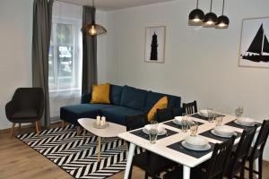 a living room with a table and a blue couch at Przystań w Pucku in Puck