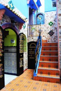 uma entrada para um edifício com portas e escadas em Hotel Casa Khaldi em Chefchaouene