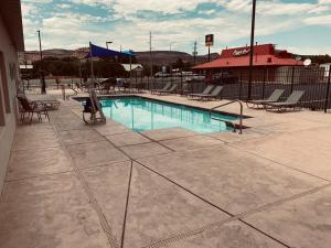 una piscina con mesas y sillas en un edificio en La Quinta by Wyndham Kanab en Kanab