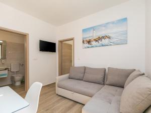 een witte woonkamer met een bank en een tv bij Apartment Stefano - free wine&spirit tasting in Višnjan