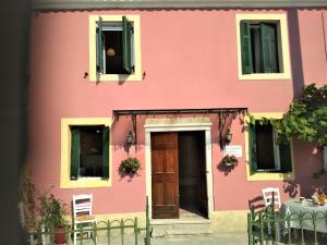 a pink building with a door and a table at RIVER HOUSE MARIA in Lefkimmi
