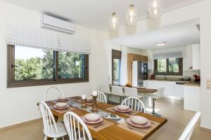 a kitchen and dining room with a wooden table and chairs at Villa Anemolia in Lefkogeia