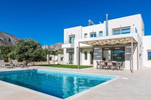a villa with a swimming pool and a house at Villa Anemolia in Lefkogeia