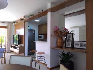 a kitchen and living room with a table and chairs at PRAIA DO FORTE - CONDOMINIO VILLAGE DAS ACACIAS - PISCINAS NATURAIS in Praia do Forte