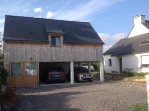 a house with a car parked in the garage at APPT T2 PROCHE PLAGE in Plouharnel