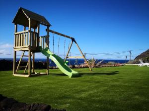 a playground with a slide on a grass field at Vistamar La Caleta in La Caleta