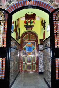 une entrée à un bâtiment avec une porte décorée dans l'établissement Hotel Casa Khaldi, à Chefchaouen