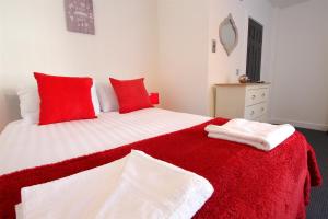 - une chambre dotée d'un lit rouge et blanc avec des oreillers rouges dans l'établissement Fabrik Apartments - 66 Central Drive, à Blackpool