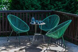 two green chairs and a table with drinks on a patio at Vaskúti Faház in Matraszentistvan