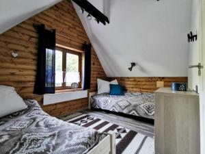 1 dormitorio con 2 camas y ventana en Vaskúti Faház, en Matraszentistvan