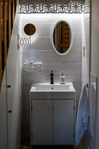 een badkamer met een witte wastafel en een spiegel bij Vaskúti Faház in Matraszentistvan