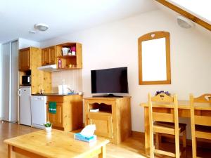 a living room with a table and a television at Studio dans résidence de tourisme*** in Giez