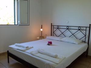 Un dormitorio con una cama con toallas y flores. en Liberatos Village, en Lassi