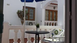 un tavolo e delle sedie su un balcone con un ombrellone di Ocean Dreams Suite heated pool a Los Cristianos