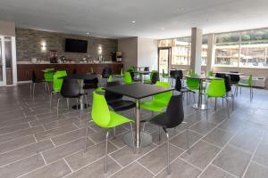 a dining room with green chairs and tables at Super 8 by Wyndham Goldsboro in Goldsboro