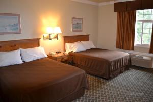a hotel room with two beds and two lamps at The Miramar Inn & Suites in Half Moon Bay