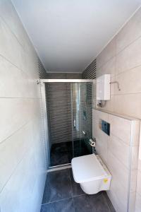 a bathroom with a toilet and a glass shower at Metins Gümüşlük in Bodrum City