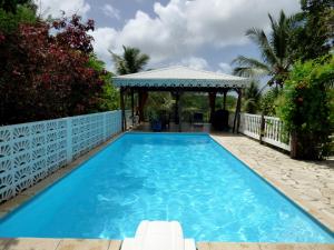 a swimming pool with a gazebo in a backyard at Les Hauts de Terrasson in Les Abymes