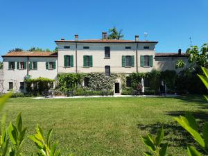 a large white house with a large yard at Corte Malpensata in San Giorgio Di Mantova