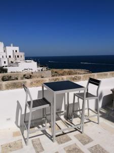 una mesa y sillas en un balcón con vistas al océano en A casa di Dany, en Polignano a Mare