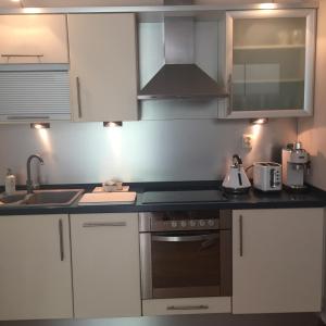 a kitchen with white cabinets and a stove top oven at Lux apartament Poznań, ul. Mostowa 19 D/5 in Poznań