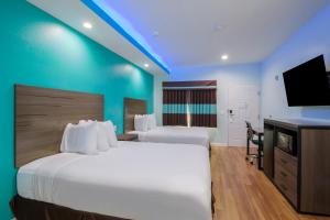 Americas Best Value Inn- Aldine Westfield tesisinde bir odada yatak veya yataklar
