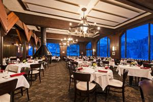 a dining room with tables and chairs and large windows at Alta's Rustler Lodge in Alta