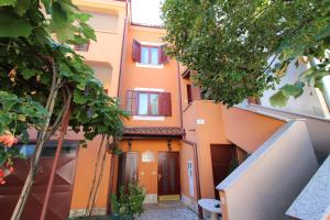 an apartment building with orange walls and trees at Apartments Grace in Rovinj
