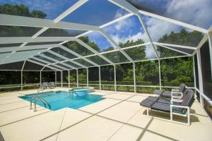 a glass house with a swimming pool and a patio at North Timucuan Trail Villa 1208 in Hernando