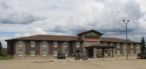 a hotel with a parking lot in front of it at Foxwood Inn and Suites in Fox Creek