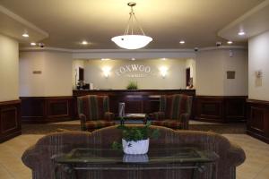a lobby with a waiting area with chairs and a table at Foxwood Inn and Suites in Fox Creek