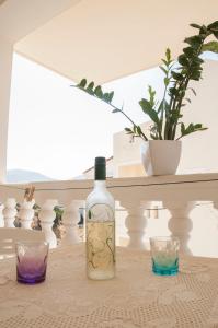 a bottle of wine and two glasses on a table at Minas-Maria House in Karpathos