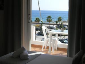 Habitación con balcón con mesa y vistas al océano. en Villa Kostandin, en Qeparo