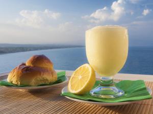 a drink and a plate of food with a lemon at Marina Blu Rooms in Castellammare del Golfo