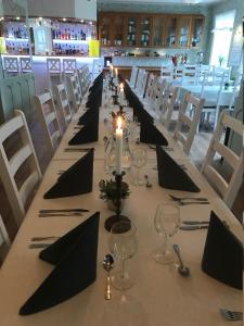 a long table with black napkins and candles on it at Hotell Paradis in Eksjö