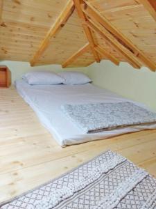 uma cama num quarto com piso em madeira em Casa Consta em Litochoro