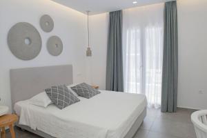 um quarto branco com uma cama e uma janela em Casabella em Naxos Chora