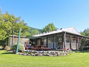 a house with a picnic table in front of it at Alpine Adventure Holiday Park in Hanmer Springs