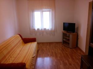 1 dormitorio con 1 cama, TV y ventana en Apartments Nadica - free parking, en Nin