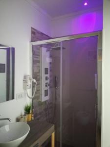 プレシッチェにあるB&B Suites Via del Mareのバスルーム(ガラス張りのシャワー、シンク付)