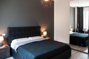 sypialnia z dużym łóżkiem z czarnym zagłówkiem w obiekcie Fiera Boutique w Bolonii