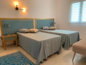two beds in a room with blue covers and a table at casa Salou individual in Salou