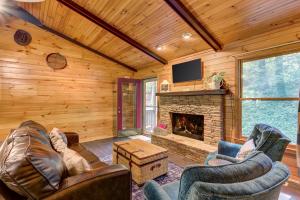 een woonkamer met lederen meubels en een open haard bij Coffee Creek Cabin in Sautee Nacoochee