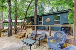 a deck with chairs and a house in the woods at Coffee Creek Cabin in Sautee Nacoochee