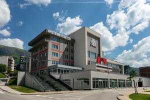 a building with a clock on the side of it at Hotel IUT in Travnik